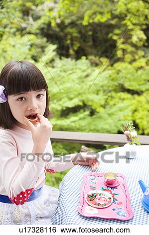 Stock Photograph - Young Girl Eating Biscuit. Fotosearch