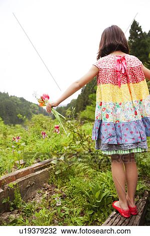 Stock Image - Young Girl Holding Flowers. Fotosearch