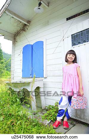 Stock Photo - Young Girl Leaning Against Playhouse. Fotosearch