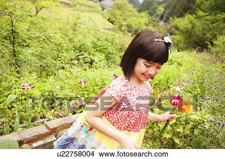 Picture - Young Girl Picking Up Flowers. Fotosearch