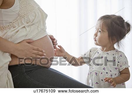 Young Girl Touching Her Pregnant Mother's Stomach View Large Photo Image Stock Photo - Young Girl Touching Her Pregnant Mother's Stomach. Fotosearch