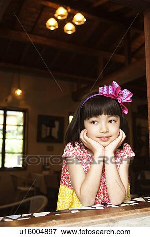 Stock Photo - Young Girl with Chin on Hands. Fotosearch