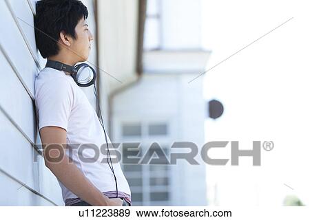 Stock Photo - Young Man Leaning Against Wall. Fotosearch