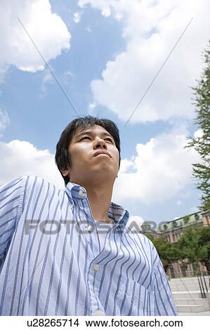 Young Man Looking Into Distance, Low Angle View View Large Photo Image Picture - Young Man Looking Into Distance, Low Angle View. Fotosearch
