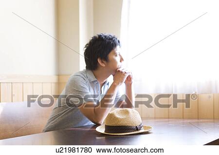 Young Man Sitting at Wooden Table View Large Photo Image Stock Image - Young Man Sitting at Wooden Table. Fotosearch