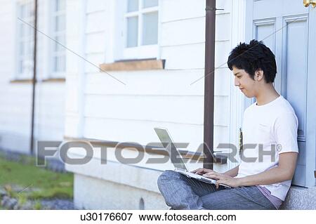 Stock Photo - Young Man Using Laptop on Steps. Fotosearch