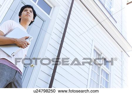 Young Man with Laptop Standing Outside Front Door View Large Photo Image Stock Image - Young Man with Laptop Standing Outside Front Door. Fotosearch