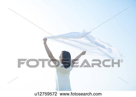 Stock Image - Young Woman Holding Up Scarf. Fotosearch