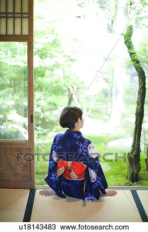 Stock Image - Young woman in Yukata Looking at Garden. Fotosearch