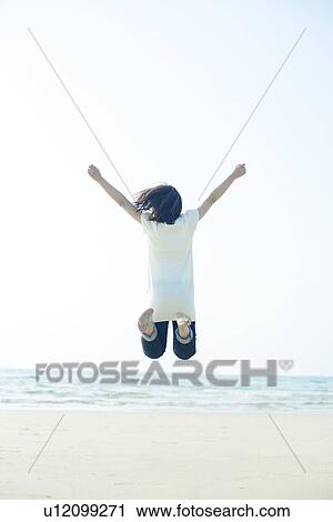 Young Woman Jumping on Beach View Large Photo Image Stock Image - Young Woman Jumping on Beach. Fotosearch