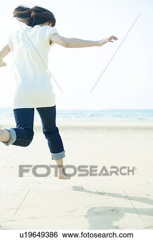Young Woman Jumping on Sand View Large Photo Image Stock Photograph - Young Woman Jumping on Sand. Fotosearch