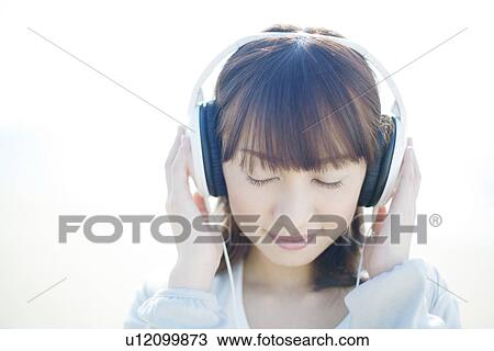 Young Woman Listening to Headphones View Large Photo Image Stock Image - Young Woman Listening to Headphones. Fotosearch