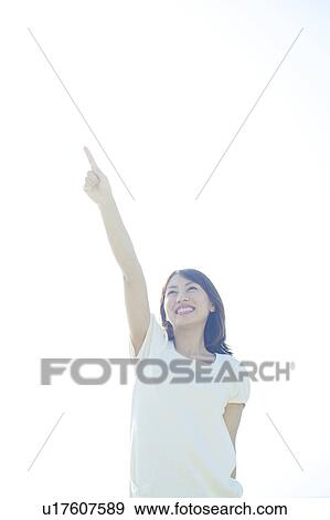 Stock Photo - Young Woman Pointing to Sky. Fotosearch