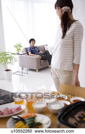 Young Woman Preparing Meal, Boyfriend in Background View Large Photo Image Stock Image - Young Woman Preparing Meal, Boyfriend in Background. Fotosearch
