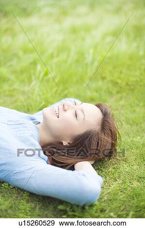 Young Woman Relaxing on Grass View Large Photo Image Stock Photo - Young Woman Relaxing on Grass. Fotosearch