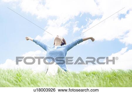Young Woman Sitting on Grass and Stretching Arms View Large Photo Image Stock Photograph - Young Woman Sitting on Grass and Stretching Arms. Fotosearch