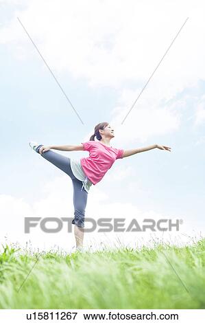 Stock Photo - Young Woman Stretching on Grass. Fotosearch