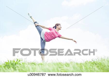 Stock Photo - Young Woman Stretching on Grass. Fotosearch