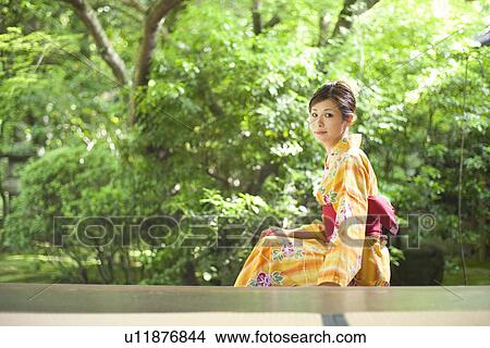 Picture - Young Woman Wearing Yukata and Looking at Garden. Fotosearch
