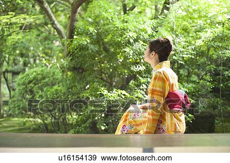 Stock Photo - Young Woman Wearing Yukata and Looking at Garden. Fotosearch