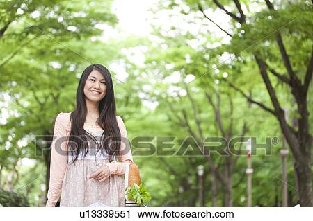 Stock Image - Young woman with a shopping bag . Fotosearch