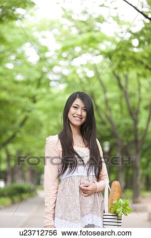 Stock Photograph - Young woman with a shopping bag . Fotosearch