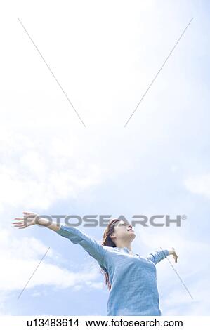 Young Woman with Arms Outstretched Against Sky View Large Photo Image Picture - Young Woman with Arms Outstretched Against Sky. Fotosearch
