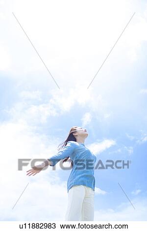 Young Woman with Arms Outstretched Against Sky View Large Photo Image Stock Image - Young Woman with Arms Outstretched Against Sky. Fotosearch