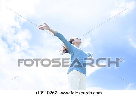 Young Woman with Arms Outstretched Against Sky View Large Photo Image Stock Image - Young Woman with Arms Outstretched Against Sky. Fotosearch