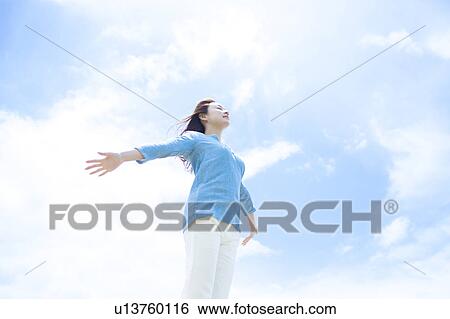 Young Woman with Arms Outstretched Against Sky View Large Photo Image Stock Photograph - Young Woman with Arms Outstretched Against Sky. Fotosearch