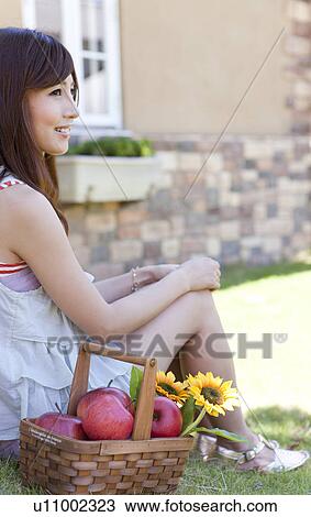Stock Image - Young Woman with Basket of Apples. Fotosearch