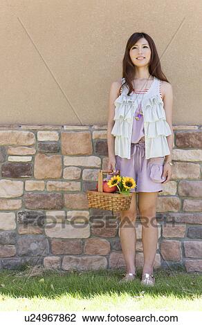 Stock Image - Young Woman with Basket of Flowers. Fotosearch