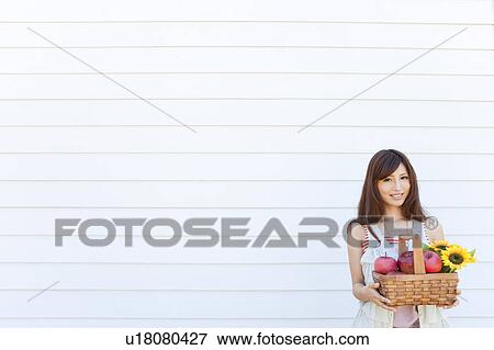 Stock Photo - Young Woman with Basket of Fruits and Flowers. Fotosearch