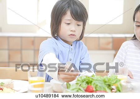 Picture - A boy having a meal. Fotosearch
