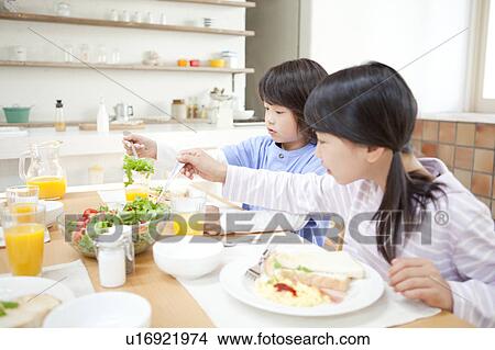 Picture - A family having a meal. Fotosearch