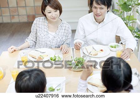 A family having a meal View Large Photo Image Stock Photograph - A family having a meal. Fotosearch