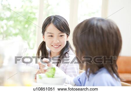 Stock Image - A girl having a meal. Fotosearch