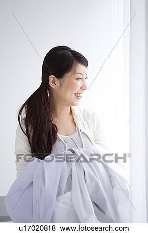 Stock Photo - A woman carrying laundry. Fotosearch