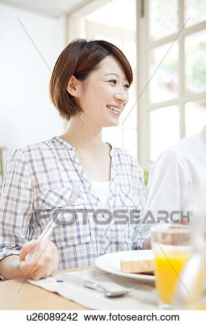 Stock Image - A woman having a meal. Fotosearch