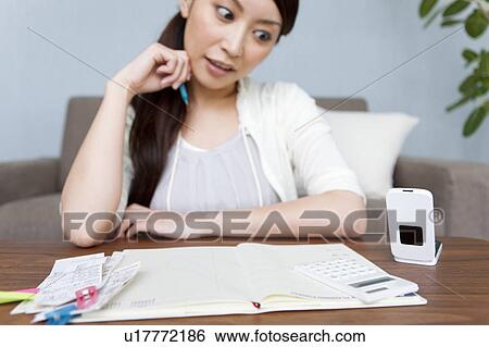 Stock Photograph - A woman keeping household accounts. Fotosearch