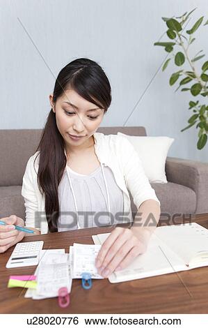 Stock Photograph - A woman keeping household accounts. Fotosearch
