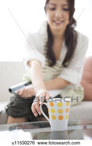A woman reaching a coffee cup View Large Photo Image Stock Photograph - A woman reaching a coffee cup. Fotosearch