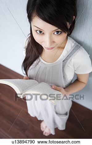 Stock Image - A woman reading a book. Fotosearch