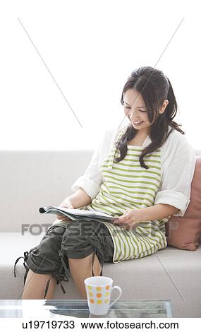Stock Image - A woman reading a magazine. Fotosearch