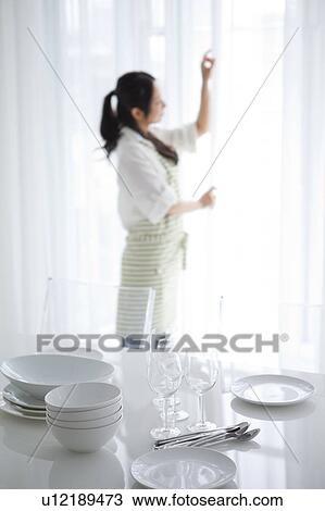 Stock Image - A woman setting a table. Fotosearch