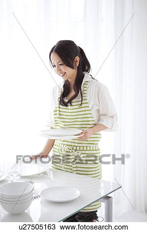 A woman setting a table View Large Photo Image Stock Image - A woman setting a table. Fotosearch