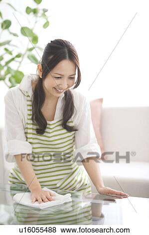 A woman wiping a table View Large Photo Image Stock Photo - A woman wiping a table. Fotosearch