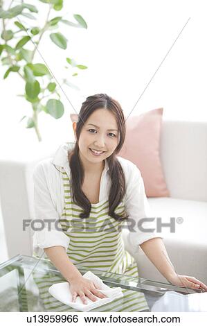 A woman wiping a table View Large Photo Image Stock Photograph - A woman wiping a table. Fotosearch