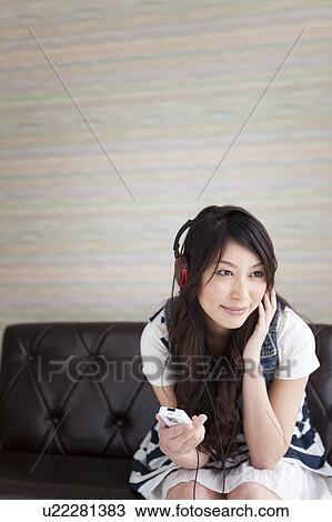 Stock Image - A young woman listening music. Fotosearch
