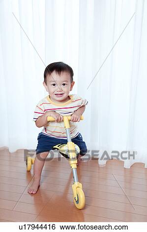 Stock Photograph - Baby Boy on Toy Tricycle. Fotosearch